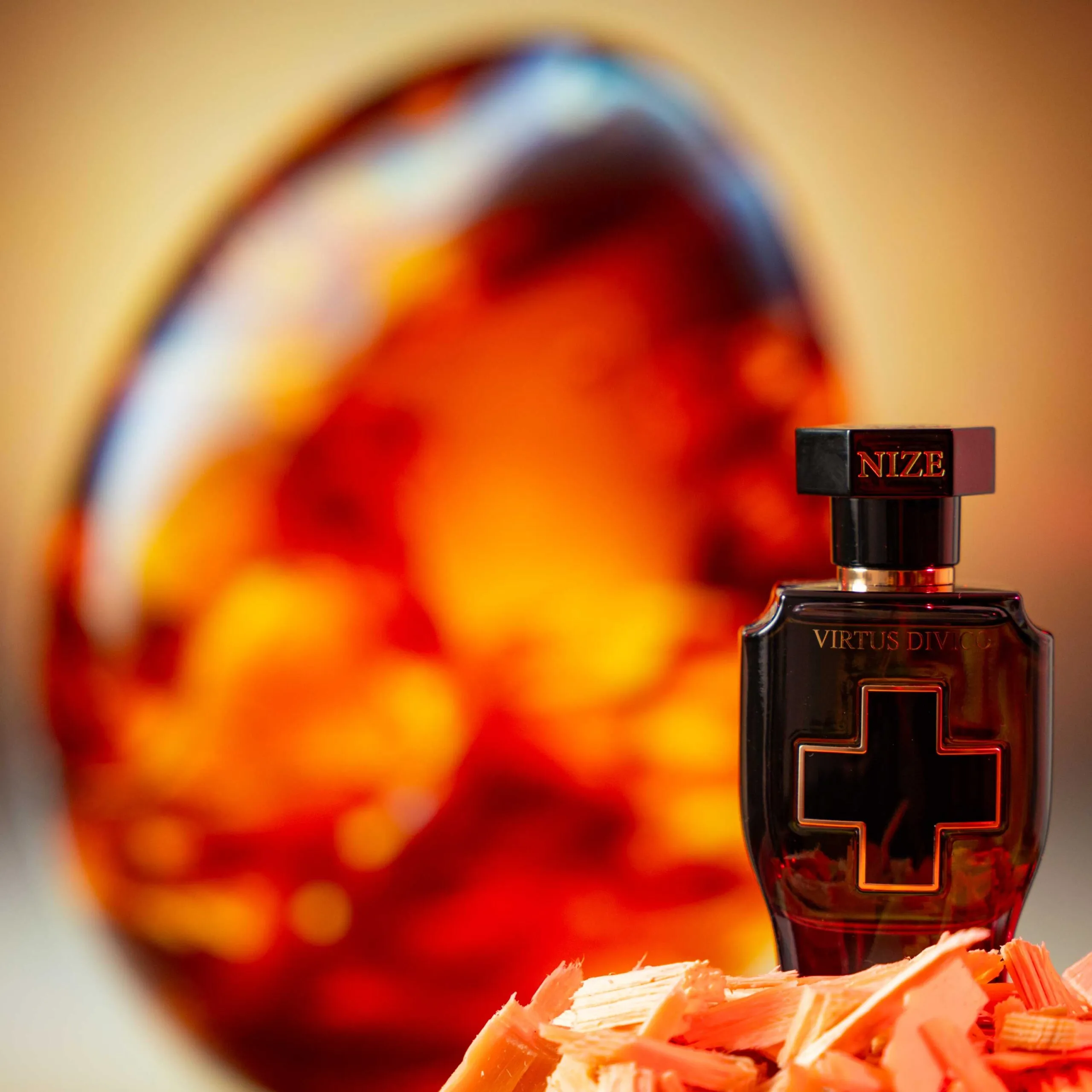 black niche perfume bottle standing in front of a piece of amber
